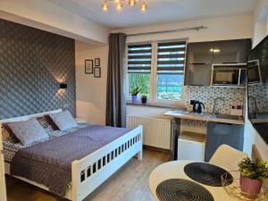 a small bedroom with a bed and a kitchen at VILLA MILA Apartamenty in Karpacz