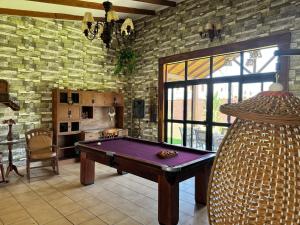a pool table in a room with a brick wall at Casa por Temporadas in Santa Cruz de la Sierra