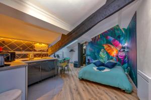 a bedroom with a tropical mural on the wall at Appart'Hotel Premium Le Roitelet - Parking Privé & Entrée Autonome in Tullins +17 photos
