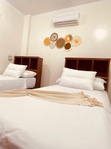 a bedroom with two beds and a air conditioner at Blue rose in Abu Simbel