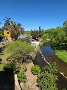 a view of a river with trees and a house at Cielo de Piedra. Cabañas y Petit Hotel in Tanti