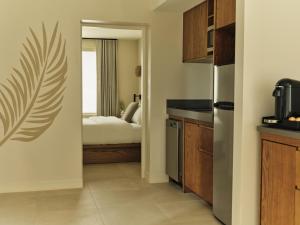 a kitchen with a room with a bed in it at Ambros Daytona, Trademark Collection by Wyndham in Daytona Beach