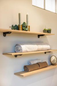 a bathroom with wooden shelves on the wall with towels at De Kompanie in Alken +50 photos