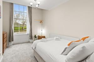 a white bedroom with a large bed and a window at Spacious 2 Bed Apartment With Secure Free Parking in Liverpool
