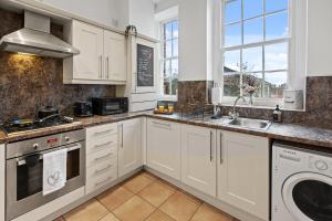 a kitchen with white cabinets and a dishwasher at Spacious 2 Bed Apartment With Secure Free Parking in Liverpool