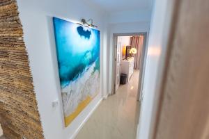a hallway with a picture of a beach on the wall at White Residence Steaua De Mare in Eforie Nord