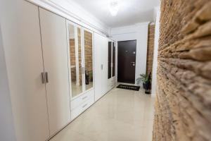 a hallway with white cabinets and a brick wall at White Residence Steaua De Mare in Eforie Nord +6 photos