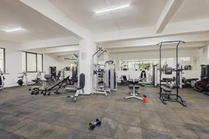 a gym with several treadmills and exercise machines at Skyline Luxury 17th-Floor 1BR near Junction Mall - City Views, Pool, Gym & Full-Body Massage Chair in Nairobi