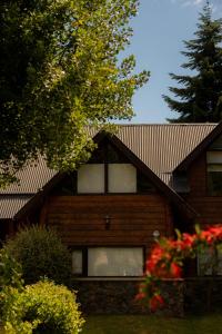 a wooden house with windows and a roof at Guardianes Del Bayo in Villa La Angostura +45 photos
