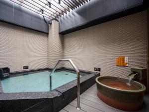 a swimming pool with a tub and a bathtub at APA Hotel Sugamo Ekimae in Tokyo