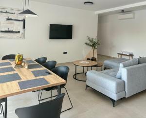 a living room with a table and chairs and a tv at White Villa, Brac in Splitska