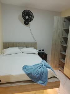 a bedroom with a bed with a blue blanket on it at Hotel y parqueadero La Colonia Inn in Socorro