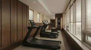 a gym with cardio machines in a room with wood walls at Metcalfe Hotel Montréal by Gray Collection in Montreal