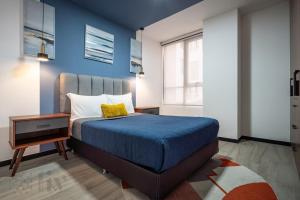a bedroom with a bed with a blue wall at Exclusive Urban HomeResort in La Cañada +149 photos