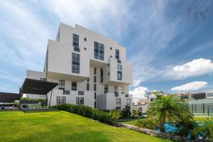 a white building with a lawn in front of it at Exclusive Urban HomeResort in La Cañada