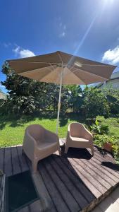 two chairs and an umbrella on a deck at Bungalow Marie in Saint-François
