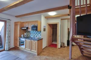 a kitchen with wooden cabinets and a flat screen tv at Ferienhof Schneiderweg in Laussa