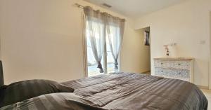 a bedroom with a large bed and a window at Maison vacances avec piscine Pennautier in Pennautier +9 photos