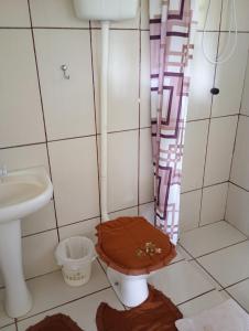 a bathroom with a toilet and a sink at cabanas sossego in Água Boa