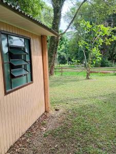 a window on the side of a house with a yard at cabanas sossego in Água Boa