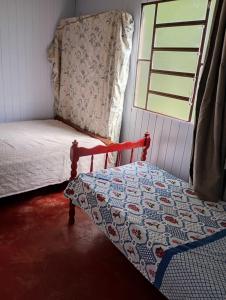 a small bedroom with a bed and a window at cabanas sossego in Água Boa
