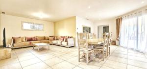 a living room with a couch and a table at Maison vacances avec piscine Pennautier in Pennautier
