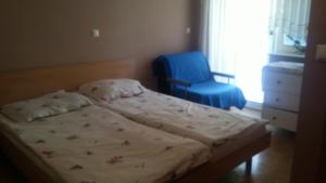 a small bedroom with a bed and a blue chair at Darja Guesthouse in Dob