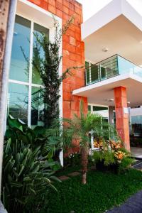 a house with a palm tree in front of it at Hotel Nacional in Jataí