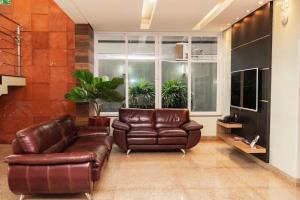a living room with a leather couch and a window at Hotel Nacional in Jataí