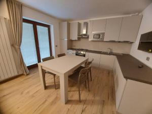 a kitchen with a table and chairs in a room at La cà de Clüsu in Clusone +7 photos