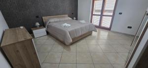 ein Schlafzimmer mit einem Bett und einem gefliesten Boden in der Unterkunft Jo Garden in Ercolano + 3 Fotos