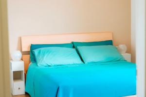 a bed with blue pillows in a bedroom at Sunset Terrace Sorrento Coast in Sant'Agnello