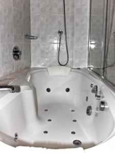 uma banheira branca na casa de banho em Hotel Jaume em Alp