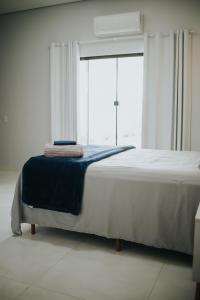 a bedroom with a bed with a blue blanket on it at casa com piscina in Sinop +57 photos