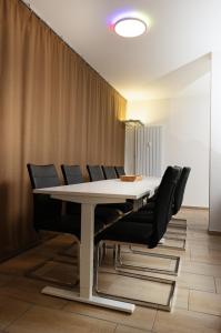 a conference room with a white table and black chairs at Private Paradise Nuremberg in Nuremberg