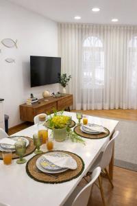 a dining room with a white table with plates of food at Almeida's House in Viana do Castelo