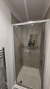 a shower with a glass door in a bathroom at Seaside 4 bed terraced house in Hastings
