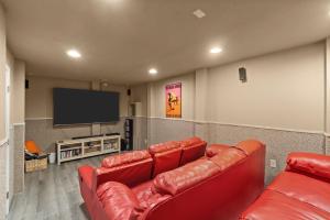 a living room with red leather couches and a flat screen tv at 8180 - Looney Dunes in Waves