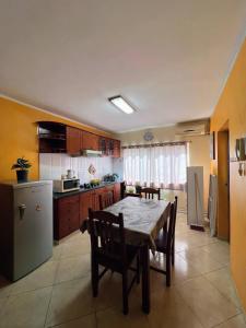 a kitchen with a table and chairs and a refrigerator at Tropical Breeze Holidays in Santa Maria