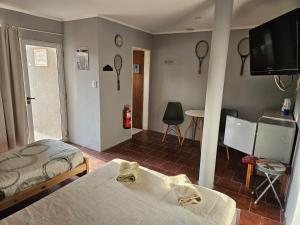 a bedroom with two beds and a flat screen tv at MARTIN TENIS CLUB in Navarro