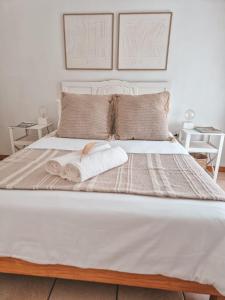 a bedroom with a bed with two towels on it at Dan en Wan in Agulhas