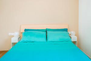 a bed with blue sheets and blue pillows at Sunset Terrace Sorrento Coast in Sant'Agnello