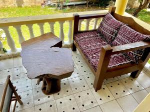 a wooden chair sitting on a porch with a table at palm ridge apartment Diani beach in Diani Beach
