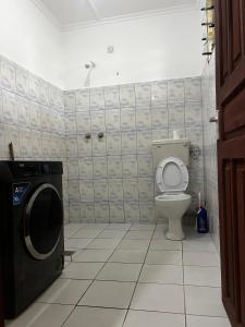 a bathroom with a toilet and a washing machine at palm ridge apartment Diani beach in Diani Beach +3 photos