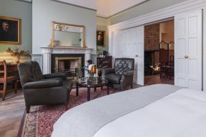 a bedroom with a bed and chairs and a fireplace at Ha'penny View House in Dublin