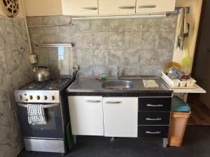 a small kitchen with a sink and a stove at Apartamento Lomas de Solymar in Ciudad de la Costa +4 photos