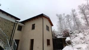 a house with snow on the side of it at Ospitalità Adocentyn in Guinadi