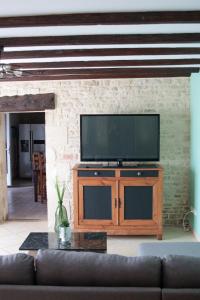 a living room with a television and a couch at Gîte des forgerons in Sainte-Ouenne