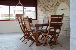 a wooden dining room table with four chairs around it at Gîte des forgerons in Sainte-Ouenne
