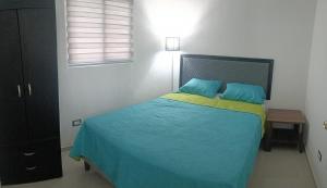 a bedroom with a bed with blue and yellow sheets at The small house in Ahuachapán +6 photos